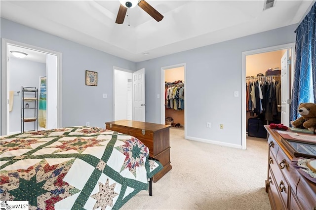 bedroom featuring a walk in closet, a closet, light carpet, and visible vents