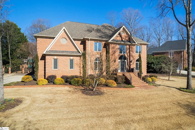 view of front of home featuring a front yard and brick siding