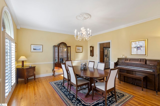204 Waterford Ln, Greer, SC 29650 - dining area with light wood-style floors, baseboards, crown molding, and an inviting chandelier