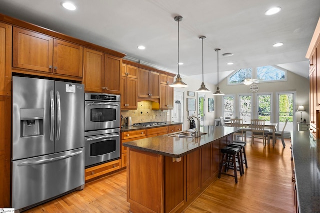 204 Waterford Ln, Greer, SC 29650 - kitchen featuring a sink, appliances with stainless steel finishes, brown cabinets, decorative backsplash, and light wood finished floors