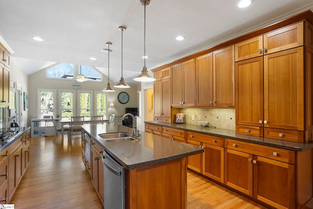 204 Waterford Ln, Greer, SC 29650 - kitchen with brown cabinets, stainless steel appliances, a sink, an island with sink, and vaulted ceiling with skylight