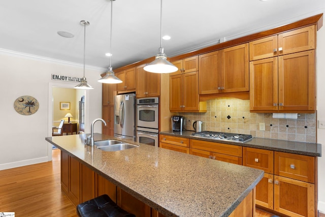 204 Waterford Ln, Greer, SC 29650 - kitchen with a kitchen island with sink, stainless steel appliances, a sink, tasteful backsplash, and brown cabinetry