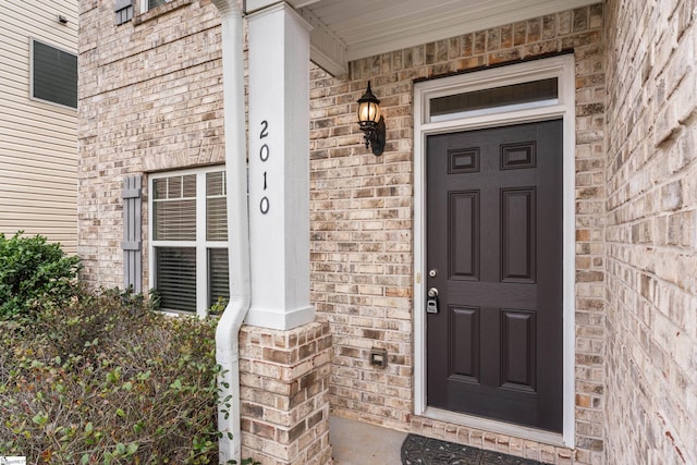 doorway to property with brick siding