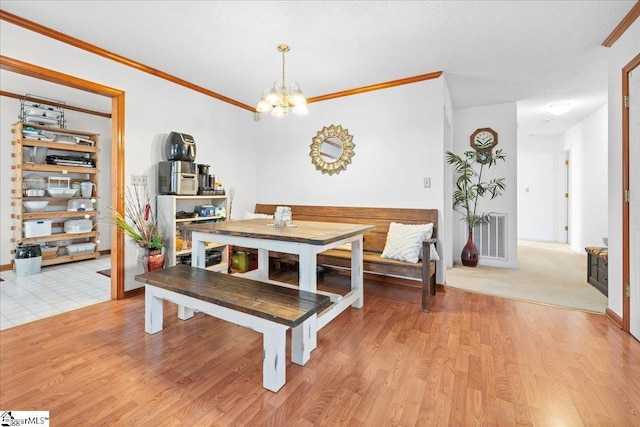 dining room with light wood-style floors, visible vents, ornamental molding, and a chandelier