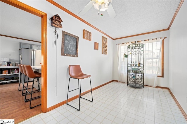 interior space with crown molding, a textured ceiling, and baseboards