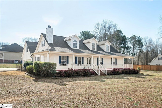 view of front facade featuring covered porch, a front yard, and fence