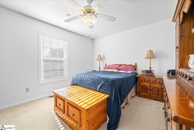 bedroom featuring a ceiling fan, baseboards, a textured ceiling, and light colored carpet