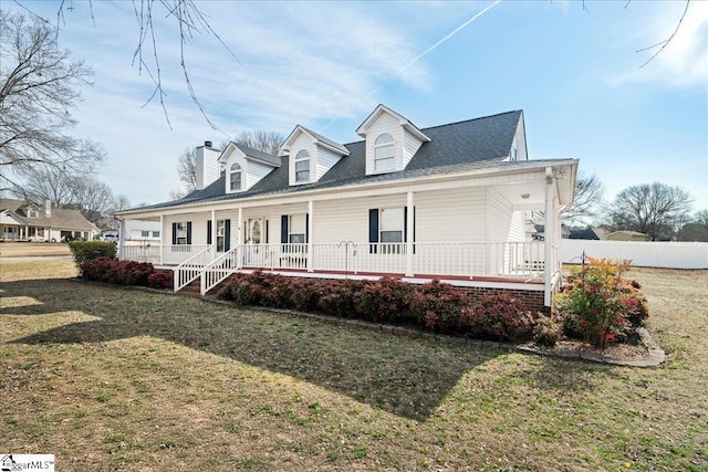 view of front of property featuring covered porch, fence, a chimney, and a front lawn