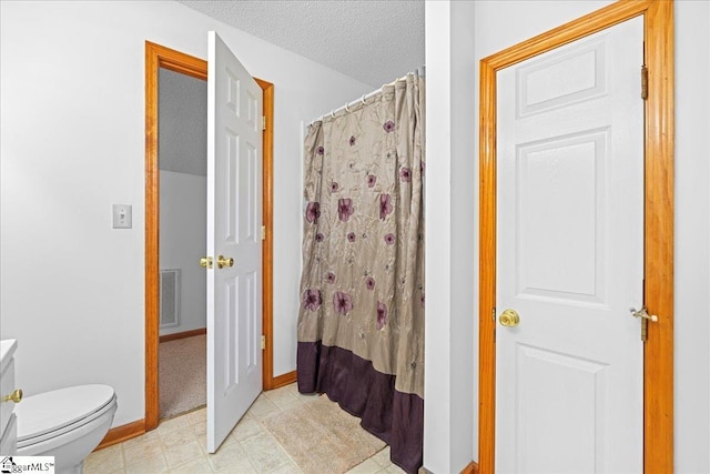 bathroom featuring a textured ceiling, curtained shower, toilet, visible vents, and baseboards