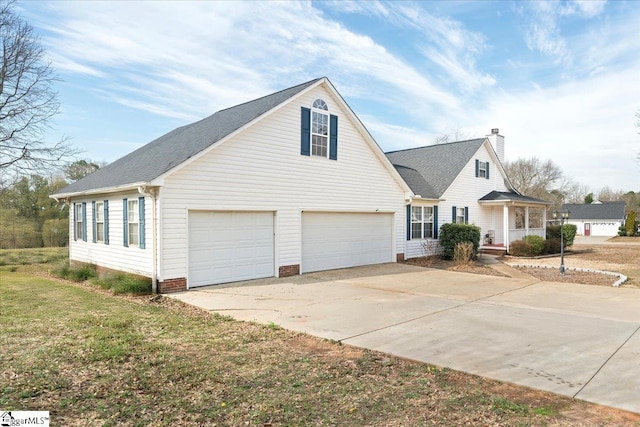 view of front facade featuring a garage, concrete driveway, a chimney, covered porch, and a front yard