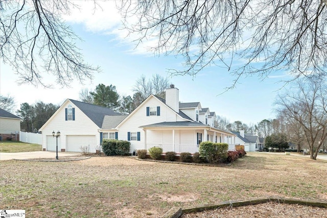 view of front of home featuring an attached garage, fence, driveway, a chimney, and a front yard