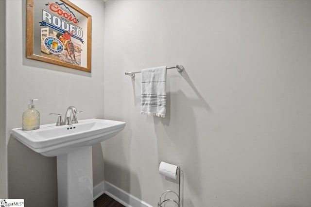 bathroom with a sink and baseboards