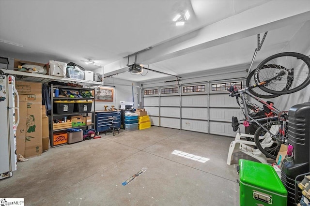 garage featuring freestanding refrigerator and a garage door opener