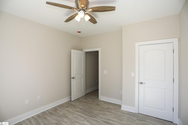 unfurnished bedroom with baseboards, ceiling fan, and light wood finished floors