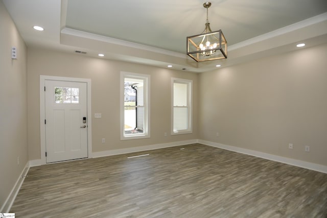 entrance foyer with recessed lighting, a raised ceiling, baseboards, and wood finished floors