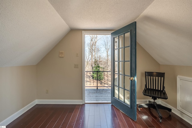 bonus room with a textured ceiling, baseboards, and wood finished floors