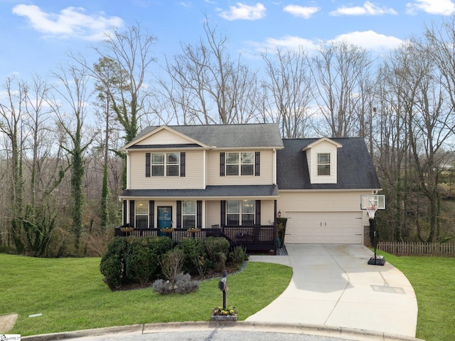 view of front facade with concrete driveway, an attached garage, covered porch, fence, and a front yard