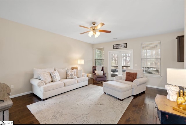 living area with dark wood-style floors, a ceiling fan, and baseboards