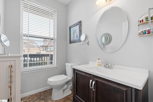 bathroom with toilet, baseboards, and vanity