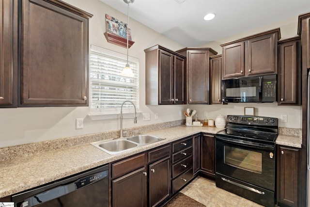 kitchen featuring light countertops, dark brown cabinets, black appliances, pendant lighting, and a sink