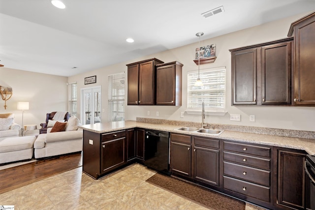 kitchen with dark brown cabinetry, black dishwasher, visible vents, open floor plan, and a sink