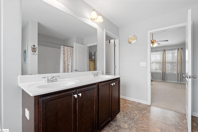 full bathroom featuring double vanity, baseboards, and a sink