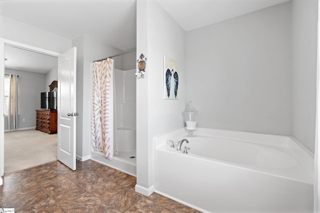 full bath with stone finish floor, a stall shower, baseboards, and a bath