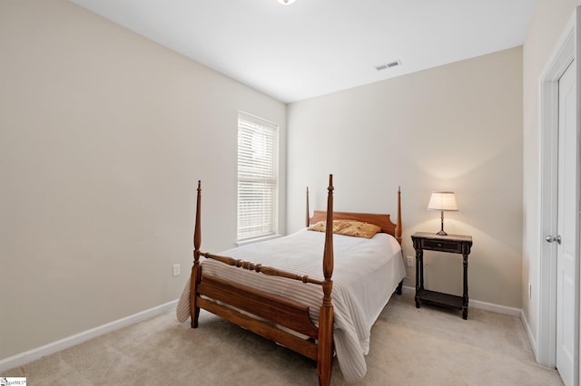 bedroom with visible vents, light carpet, and baseboards