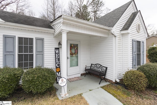 entrance to property with roof with shingles