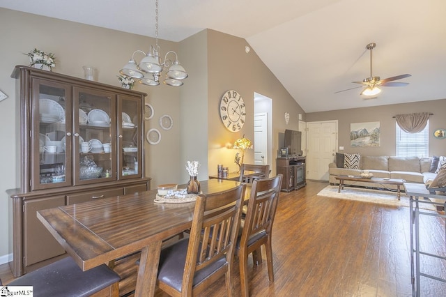 dining area with high vaulted ceiling, ceiling fan with notable chandelier, and wood finished floors