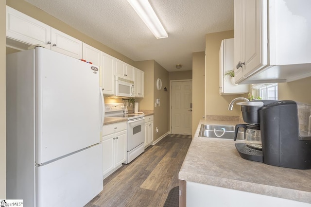 kitchen featuring white appliances, dark wood-type flooring, a sink, white cabinetry, and light countertops