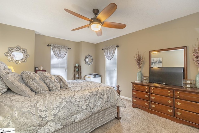 bedroom featuring baseboards, a ceiling fan, and light colored carpet