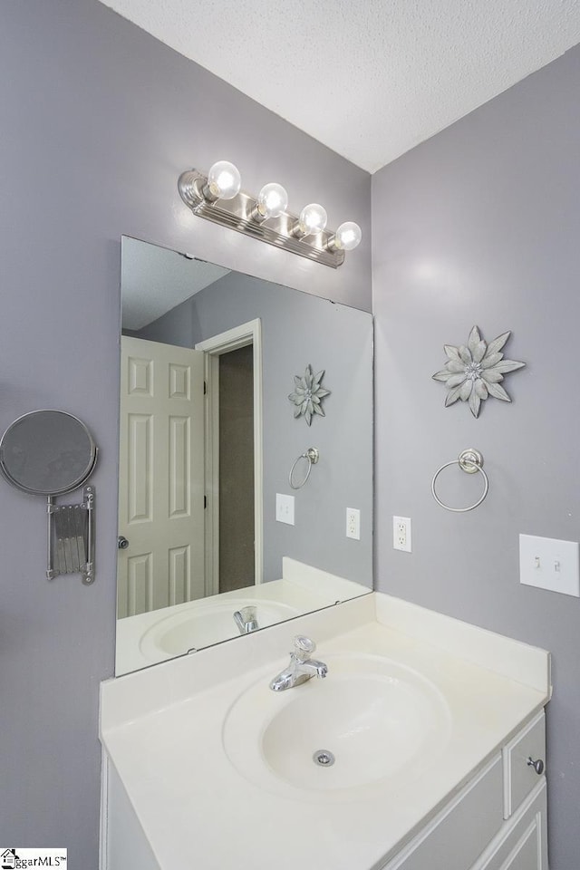 bathroom with a textured ceiling and vanity