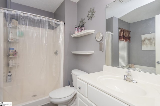 bathroom featuring a textured ceiling, a stall shower, vanity, and toilet