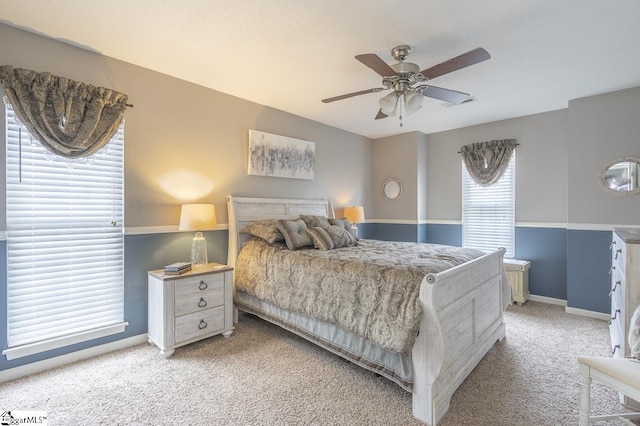 bedroom with a ceiling fan, light carpet, and baseboards