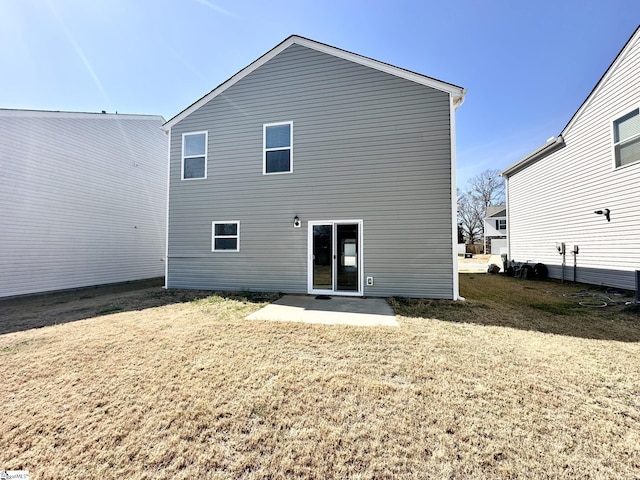 rear view of property featuring a yard and a patio area