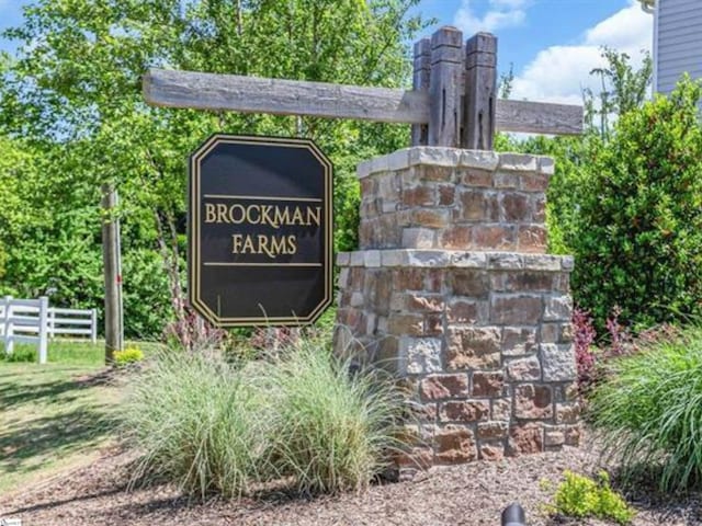 community / neighborhood sign featuring fence