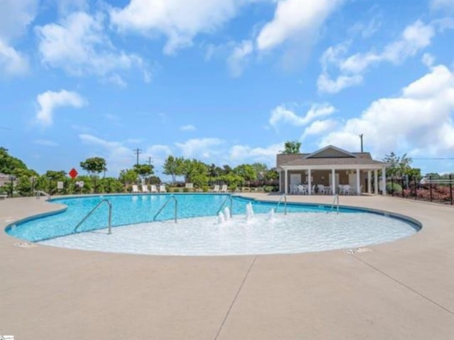 community pool featuring fence and a patio