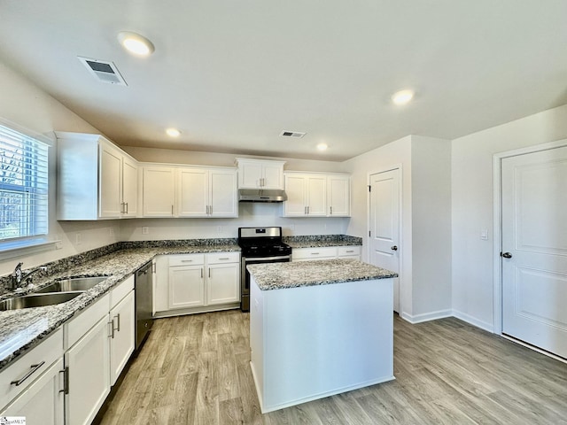 kitchen with light wood finished floors, visible vents, appliances with stainless steel finishes, under cabinet range hood, and a sink