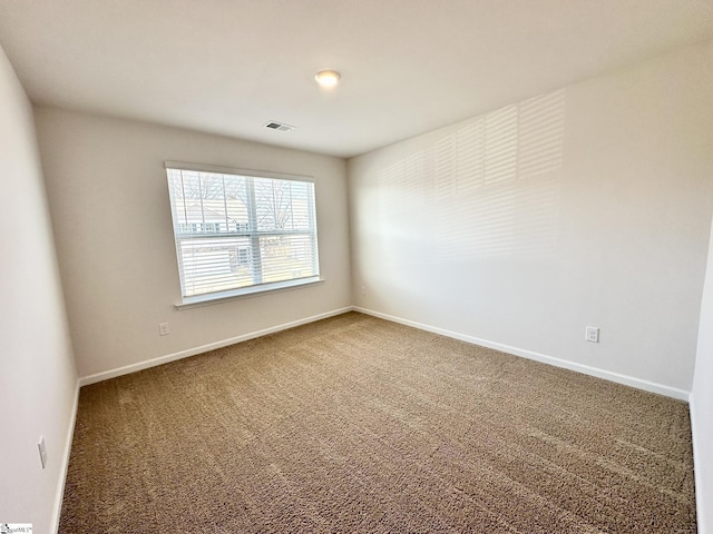 carpeted spare room with visible vents and baseboards