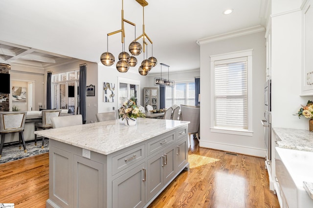 kitchen featuring crown molding, gray cabinets, an inviting chandelier, light wood-style floors, and coffered ceiling