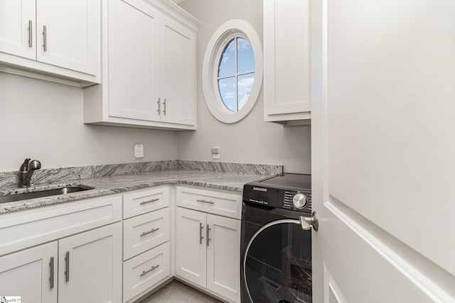 washroom featuring washer / clothes dryer, a sink, and cabinet space