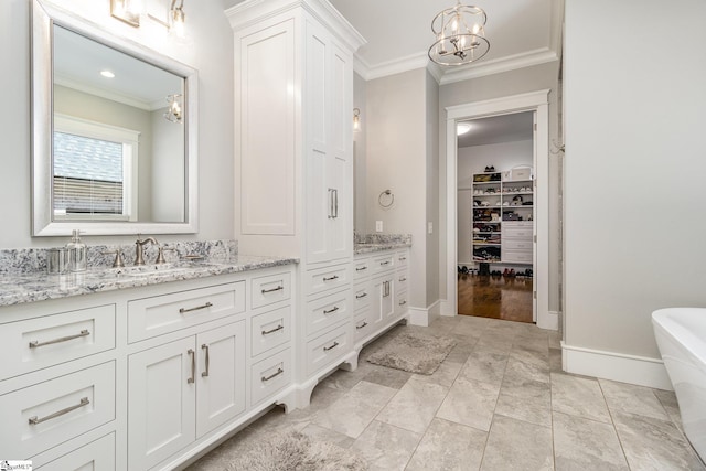 full bathroom with a freestanding bath, baseboards, crown molding, and vanity