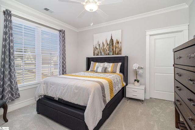 bedroom with ceiling fan, light colored carpet, visible vents, baseboards, and ornamental molding