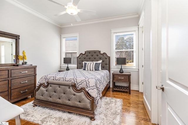 bedroom featuring ceiling fan, ornamental molding, wood finished floors, and baseboards