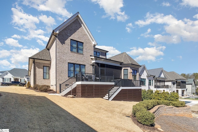 view of front of house with a residential view, brick siding, and stairs