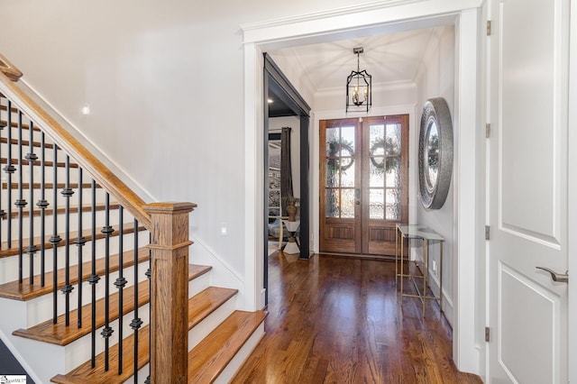 entryway with a notable chandelier, wood finished floors, stairs, french doors, and ornamental molding