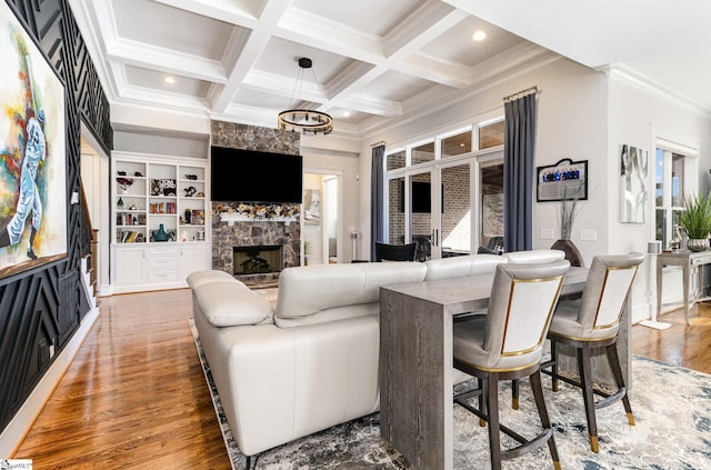 living room featuring beam ceiling, recessed lighting, a stone fireplace, wood finished floors, and coffered ceiling