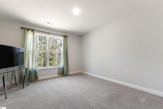 unfurnished living room with carpet, visible vents, and baseboards