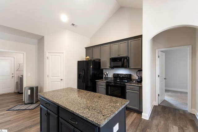 kitchen featuring arched walkways, stone countertops, dark wood-style flooring, visible vents, and black appliances